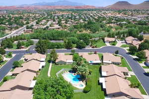 Aerial view of residential area featuring a mountain backdrop and a pool