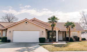 Mediterranean / spanish home with a tiled roof, stucco siding, driveway, and a garage