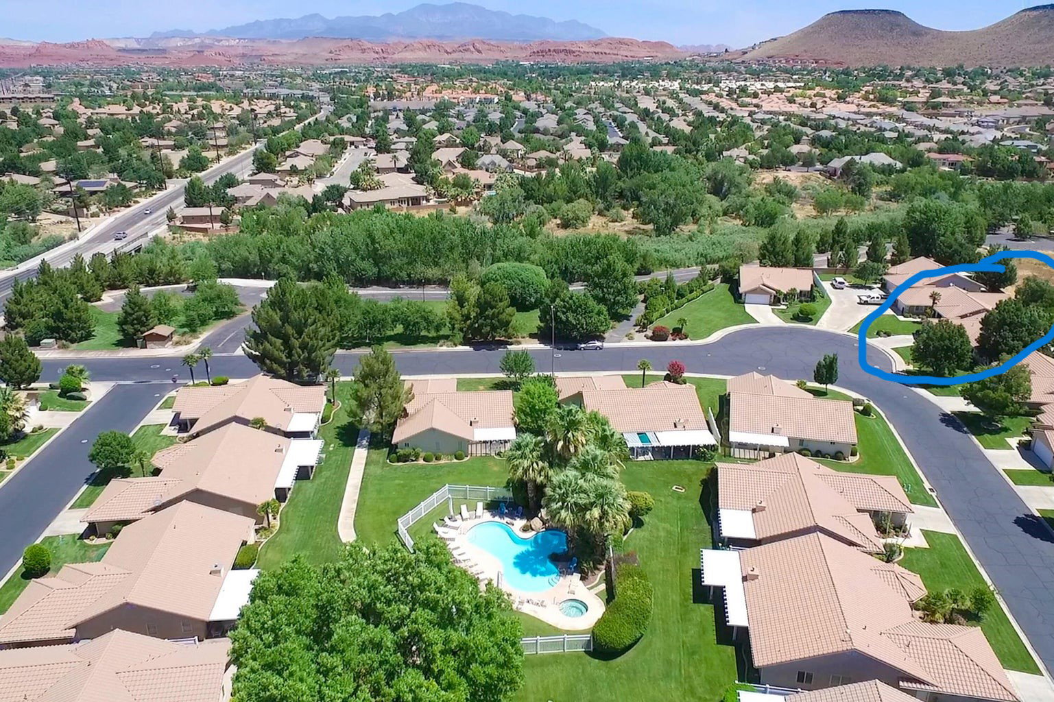 Aerial view of residential area with a mountainous background and a pool area