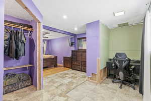 Bedroom with a desk, a textured ceiling, and a closet
