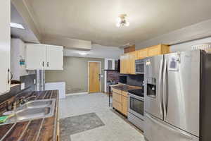 Kitchen featuring stainless steel appliances, light flooring, and light wood finish cabinets