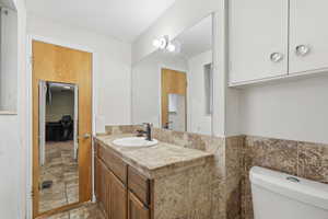 Bathroom with vanity and light stone finish flooring