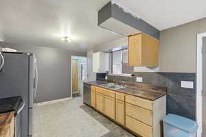 Kitchen featuring butcher block counters, electric range, light wood finish cabinetry, and stainless steel dishwasher