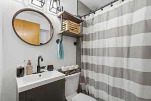 Bathroom with vanity, curtained shower, and a textured ceiling