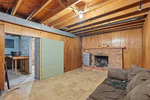 Basement with wooden walls, a fireplace, and parquet floors