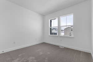 Carpeted empty room with baseboards