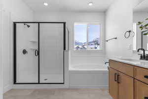 Bathroom featuring vanity, a shower stall, a mountain view, a garden tub, and recessed lighting