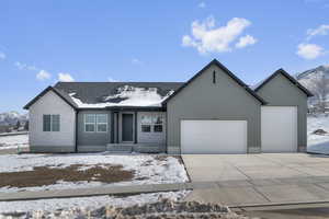 Single story home with a mountain view, a garage, concrete driveway, and brick siding