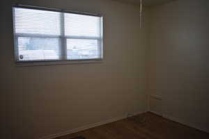 Unfurnished room with baseboards and dark wood finished floors