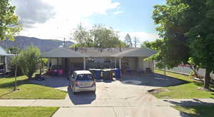 View of front of house featuring a front lawn, a mountain view, a carport, and driveway