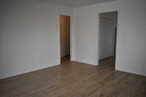Unfurnished bedroom with wood finished floors and baseboards