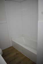 Full bath featuring dark wood finished floors