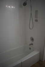 Bathroom with  shower combination and dark wood finished floors