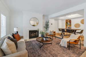 Living area with a fireplace and ornamental molding