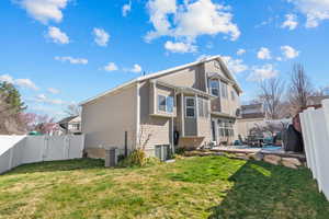 Rear view of house with a fenced backyard, a gate, and a patio