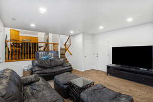 Carpeted living room featuring stairs and recessed lighting