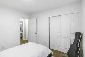 Bedroom featuring dark carpet and a closet