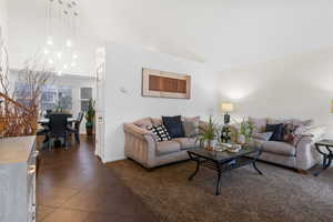 Living area featuring dark tile patterned flooring and vaulted ceiling