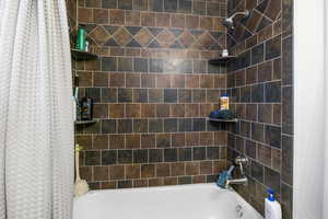 Bathroom with shower / bath combination with curtain