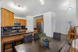 Tiled dining space featuring a sink and lofted ceiling