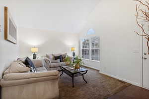 Living area with vaulted ceiling and carpet
