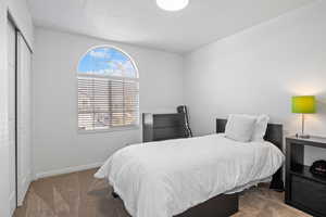 Bedroom featuring dark colored carpet and a closet