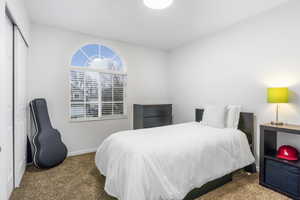 Carpeted bedroom featuring a closet and baseboards