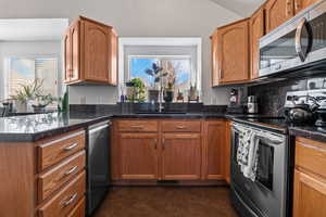 Kitchen with stainless steel appliances, wood finish cabinetry, a peninsula, and backsplash