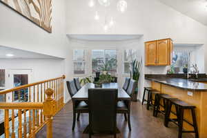 Dining space featuring healthy amount of natural light, dark tile patterned floors, and vaulted ceiling