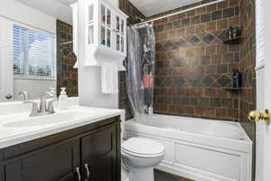 Bathroom with shower / bathtub combination with curtain and vanity