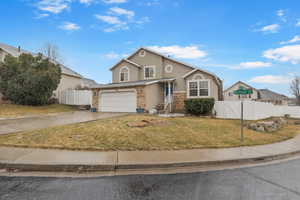 View of front of house with brick siding, driveway, a garage, stucco siding, and a gate