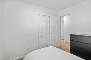 Bedroom featuring light colored carpet and a closet