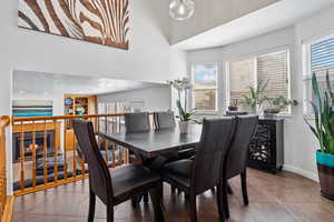 Tiled dining space with a glass covered fireplace and baseboards