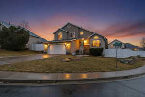 Traditional-style house featuring a gate, concrete driveway, stucco siding, and an attached garage