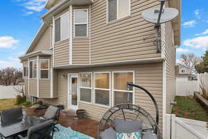Rear view of property with a fenced backyard and a patio
