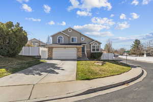 Traditional-style home featuring concrete driveway, stucco siding, a garage, and a gate