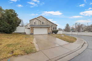 Traditional-style house with a gate, stucco siding, driveway, and an attached garage