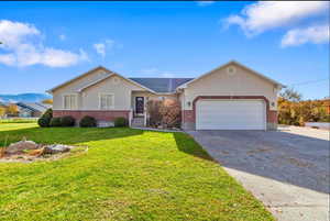 Ranch-style home featuring brick siding, a mountain view, concrete driveway, and stucco siding