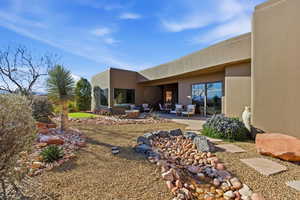 Rear view of property with a patio, stucco siding, and a fire pit