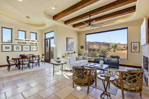 Living area featuring a raised ceiling, beam ceiling, a mountain view, recessed lighting, and a ceiling fan