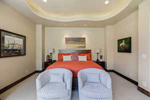 Bedroom with recessed lighting, light colored carpet, and a tray ceiling