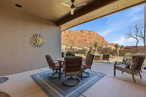 Fenced backyard with a ceiling fan, outdoor dining space, a patio, and a mountain view