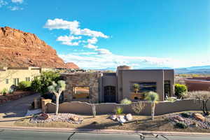 View of front of home with a mountain view, stucco siding, and stone siding