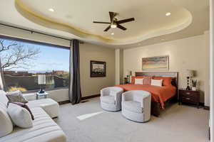 Bedroom with light colored carpet, recessed lighting, a ceiling fan, and a tray ceiling