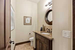 Half bath featuring vanity and stone tile floors