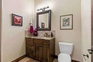 Half bathroom with vanity and tasteful backsplash