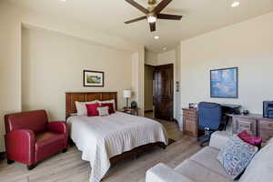 Bedroom featuring light wood finished floors, ceiling fan, and recessed lighting