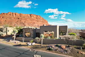 Pueblo-style house with stucco siding and stone siding