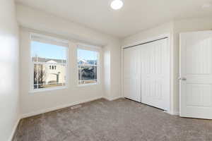Unfurnished bedroom featuring carpet and a closet