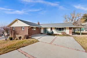 Ranch-style home featuring brick siding, a chimney, a front lawn, and a shingled roof